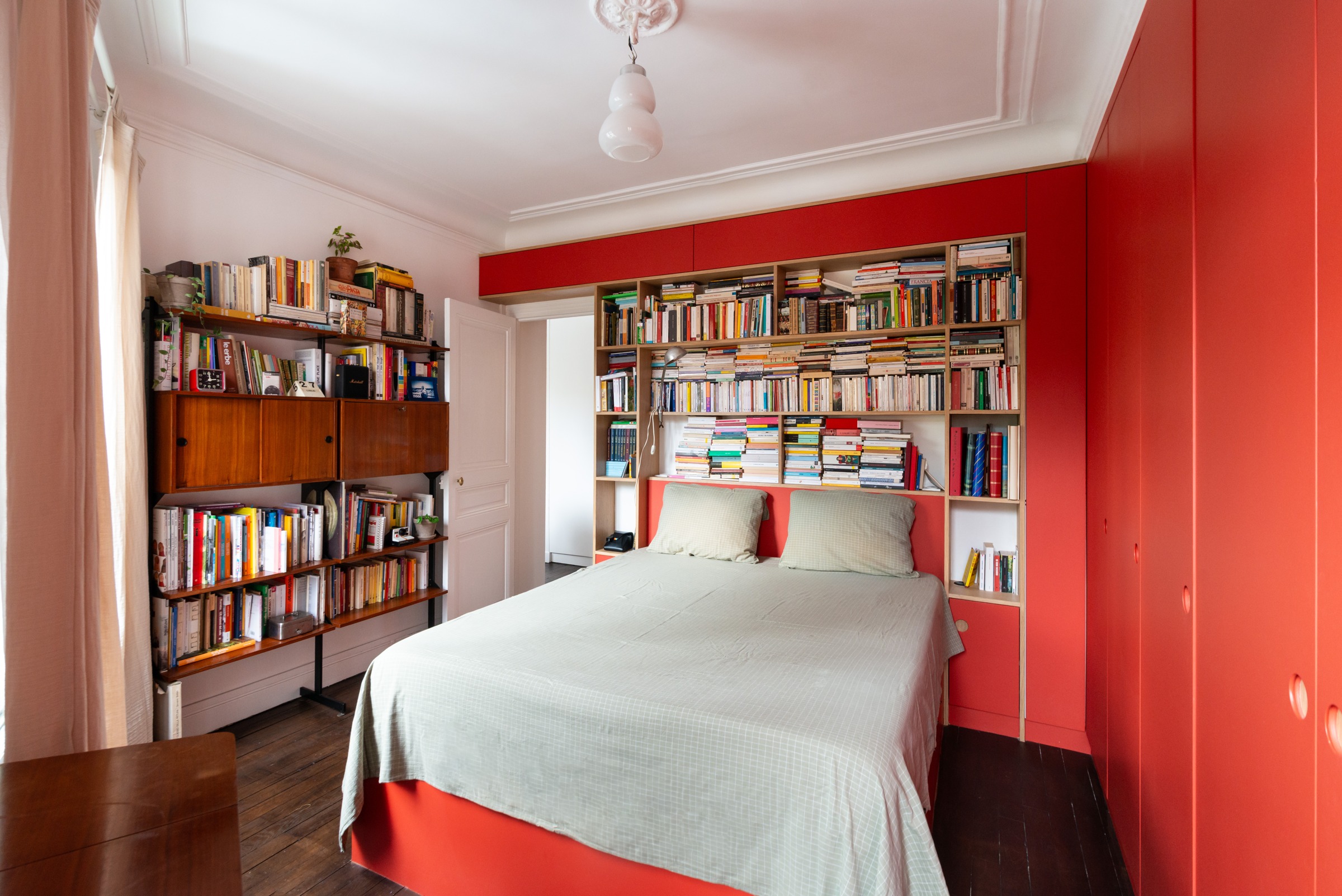 Chambre à Paris 20e avec bibliothèque et grands placards rouges réalisés sur mesure