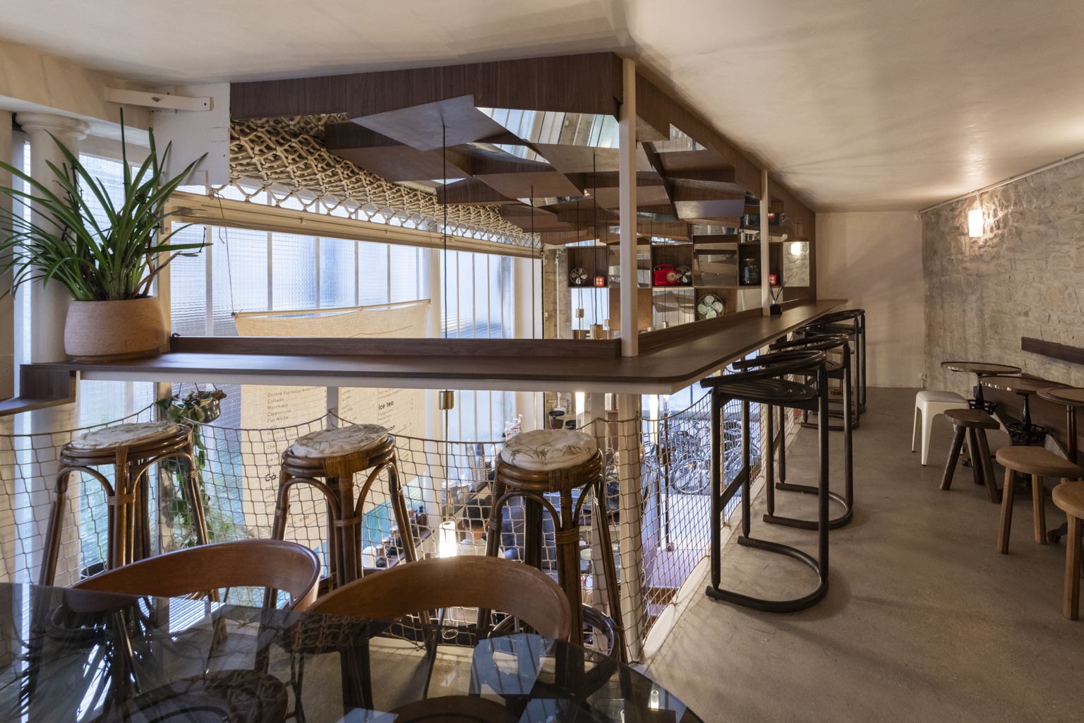 Places assises et comptoir du café du Marais, avec grandes baies vitrées