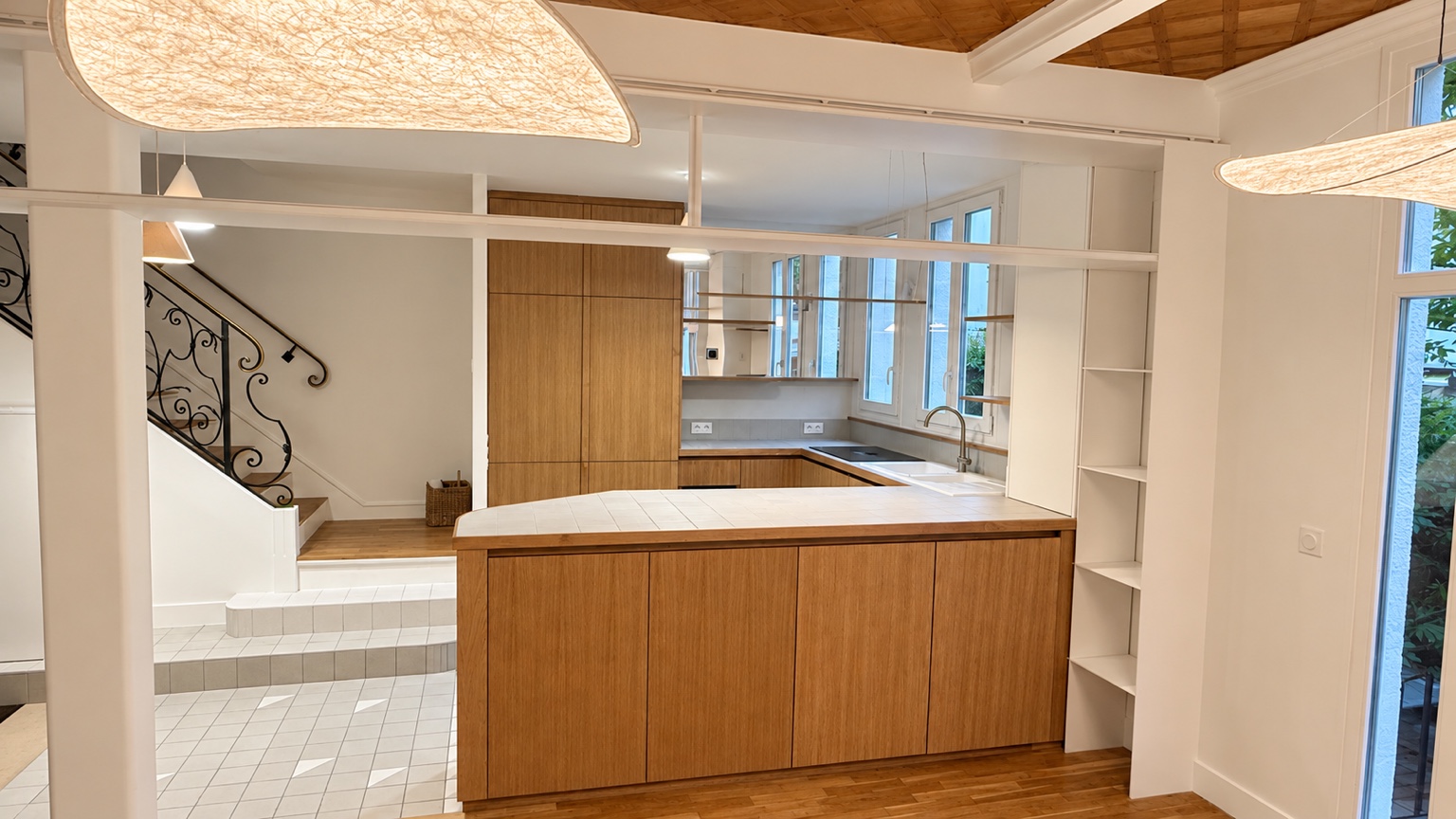 Cuisine aux lignes courbes et menuiseries en bois, maison rénovée par Luca Renove à Paris 13e