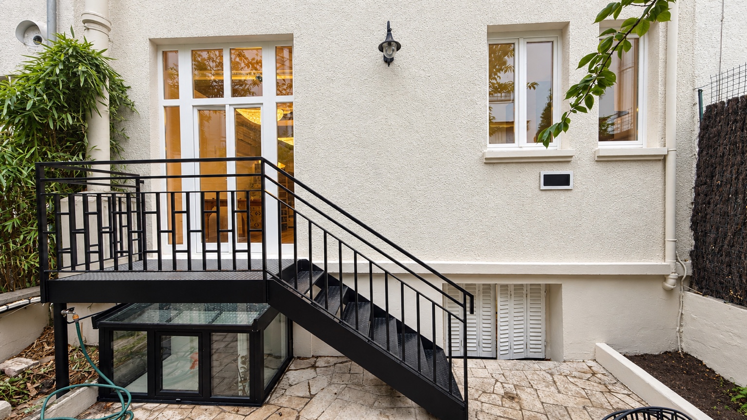 Façade sur cour de la maison à Paris 13e, avec escalier extérieur et garde-corps sombre