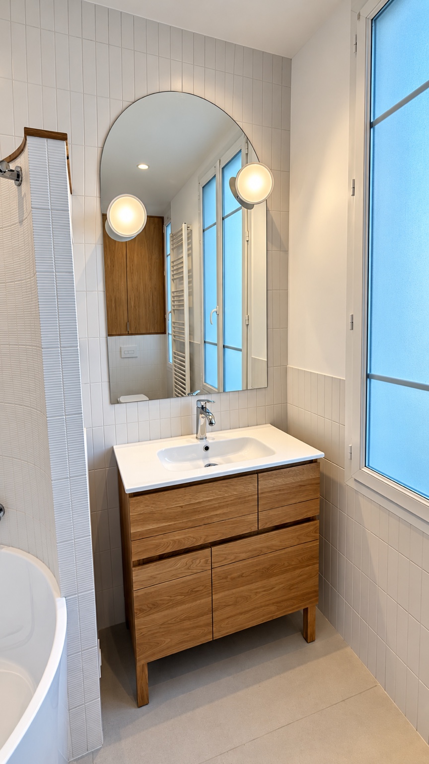 Salle de bains à Paris 13e avec meuble vasque en bois et miroir cintré